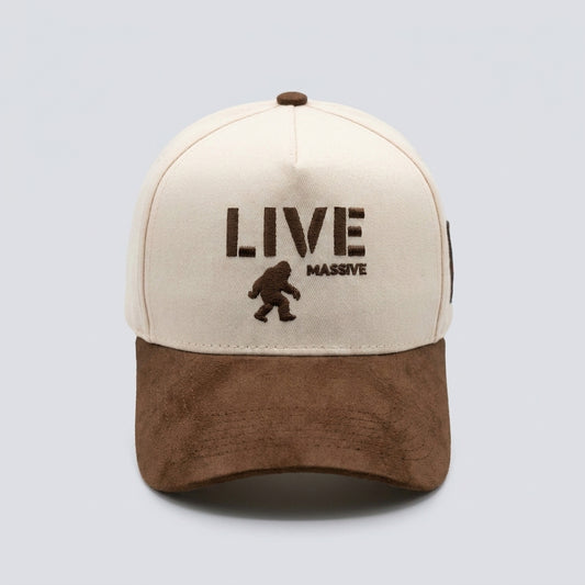 Live Massive SmartSquatch snapback hat - front view, cream crown with LIVE MASSIVE 3D wordmark and bigfoot silhouette, brown suede brim