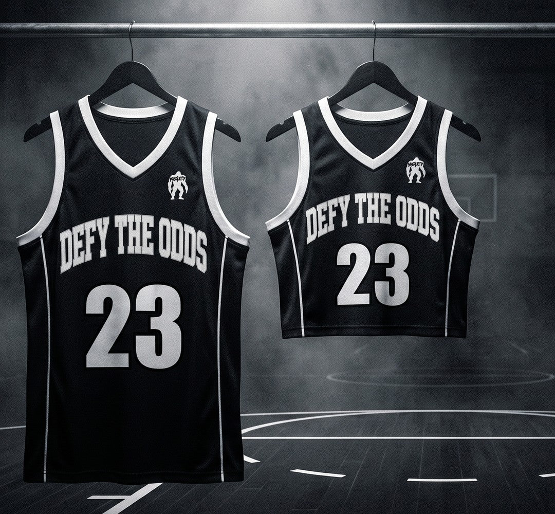 Defy The Odds men's full-length and women's cropped jerseys hanging under a spotlight